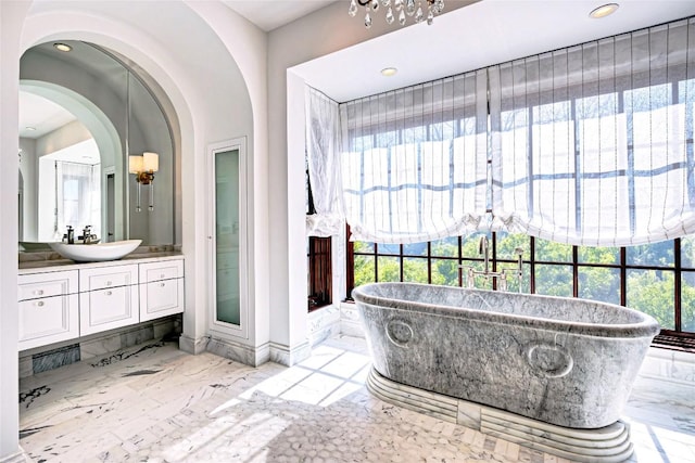bathroom featuring recessed lighting, a soaking tub, marble finish floor, and vanity