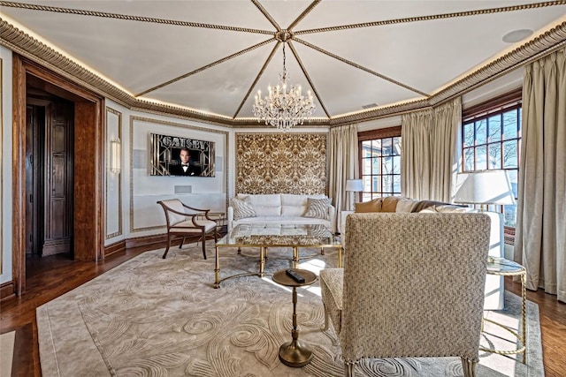 sitting room featuring crown molding, an inviting chandelier, wood finished floors, and vaulted ceiling