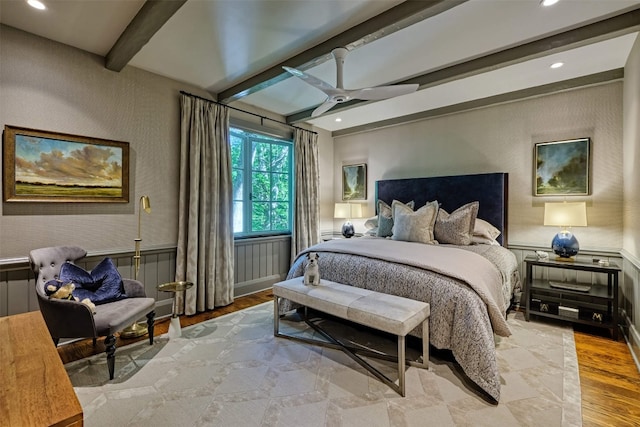 bedroom with ceiling fan, wainscoting, beamed ceiling, recessed lighting, and light wood-style flooring