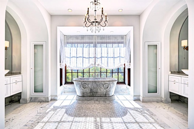 bathroom featuring vanity, baseboards, a soaking tub, and marble finish floor