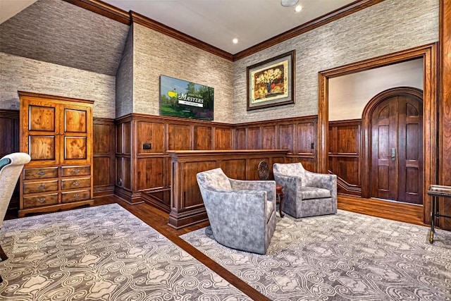 living area with crown molding, a wainscoted wall, and wood finished floors