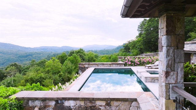 outdoor pool featuring an in ground hot tub and a mountain view