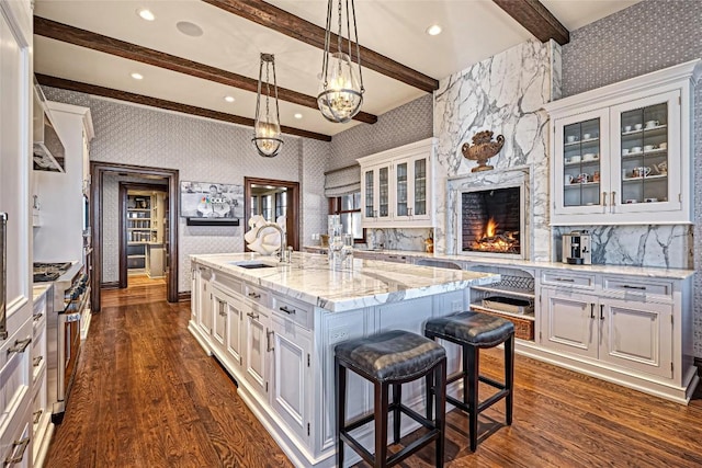 kitchen featuring beamed ceiling, wallpapered walls, and dark wood-style floors