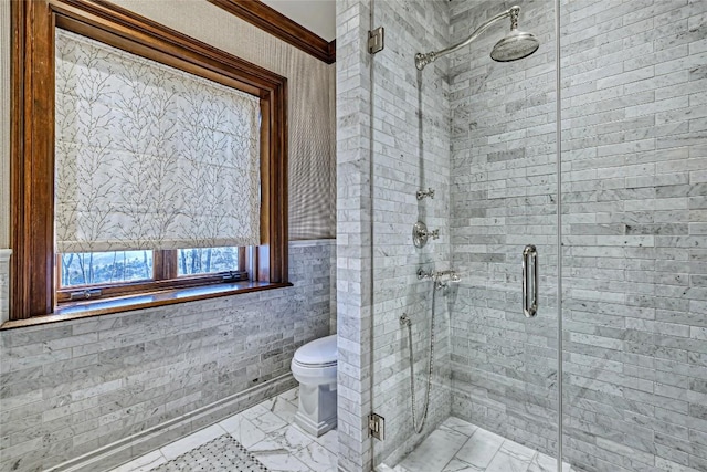 full bathroom featuring ornamental molding, marble finish floor, a stall shower, and toilet