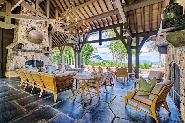 view of patio with an outdoor living space with a fireplace, a gazebo, and a mountain view