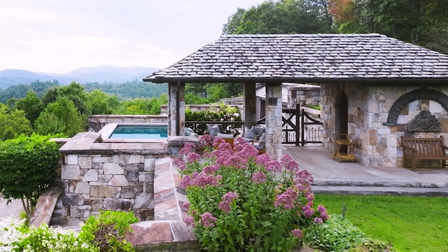 view of patio / terrace featuring a mountain view and a hot tub