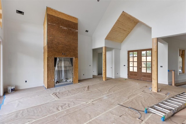 148 E Ridge Rd, Cashiers, NC 28717 - unfurnished living room featuring high vaulted ceiling, french doors, a fireplace, and baseboards