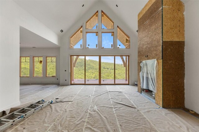 148 E Ridge Rd, Cashiers, NC 28717 - unfurnished living room featuring high vaulted ceiling and healthy amount of natural light