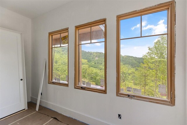 148 E Ridge Rd, Cashiers, NC 28717 - empty room with baseboards and a forest view