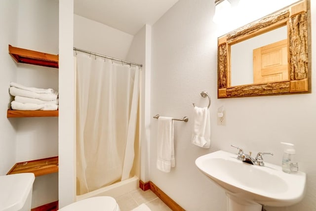 bathroom with tile patterned flooring, a sink, a shower stall, and toilet