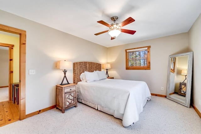 bedroom featuring light carpet, a ceiling fan, and baseboards