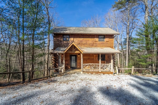 view of front of property featuring covered porch and fence