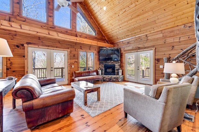 living area featuring light wood-style flooring, wood ceiling, french doors, and wooden walls