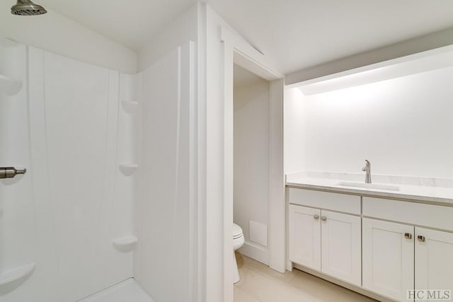 bathroom with vanity, walk in shower, tile patterned floors, and toilet