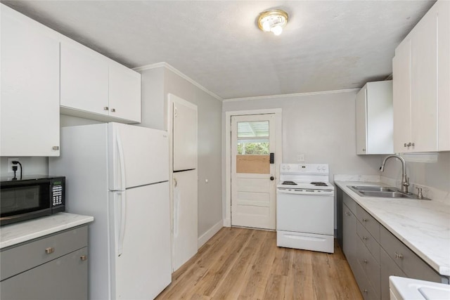 kitchen featuring ornamental molding, white appliances, light wood-type flooring, gray cabinets, and a sink