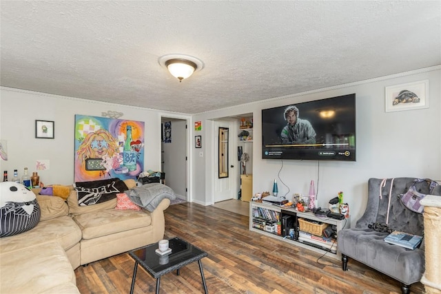living area with crown molding, a textured ceiling, and wood finished floors