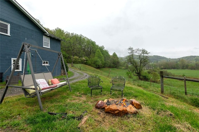 view of yard with an outdoor fire pit and fence