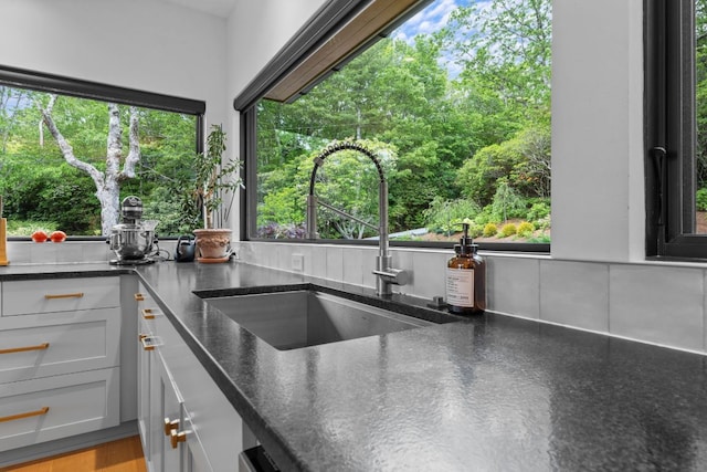 1240 King Gap Rd, Highlands, NC 28741 - kitchen featuring dark stone counters, white cabinetry, and view of wooded area