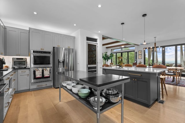1240 King Gap Rd, Highlands, NC 28741 - kitchen with stainless steel appliances, light wood-type flooring, gray cabinetry, recessed lighting, and a center island