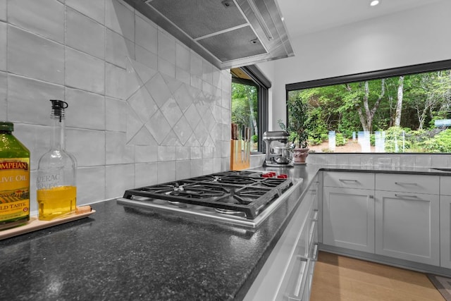 1240 King Gap Rd, Highlands, NC 28741 - kitchen featuring stainless steel gas cooktop, exhaust hood, backsplash, and dark stone counters