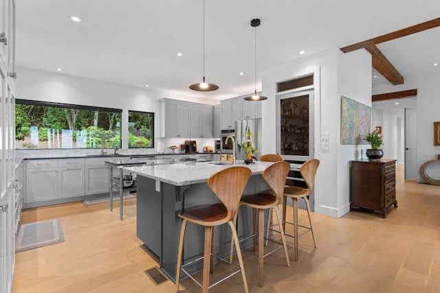 1240 King Gap Rd, Highlands, NC 28741 - kitchen with light wood-type flooring, tasteful backsplash, recessed lighting, gray cabinetry, and a kitchen island with sink