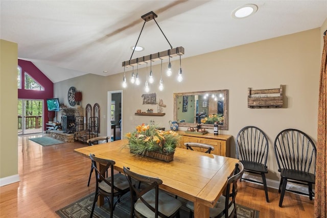 151 Rhododendron Ct, Sapphire, NC 28774 - dining space with light wood finished floors, vaulted ceiling, and a fireplace with raised hearth