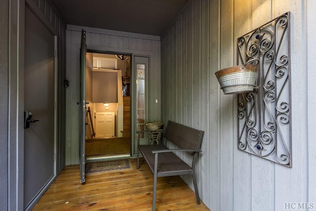 doorway featuring hardwood / wood-style flooring and wooden walls