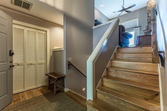 stairs featuring hardwood / wood-style flooring and ceiling fan