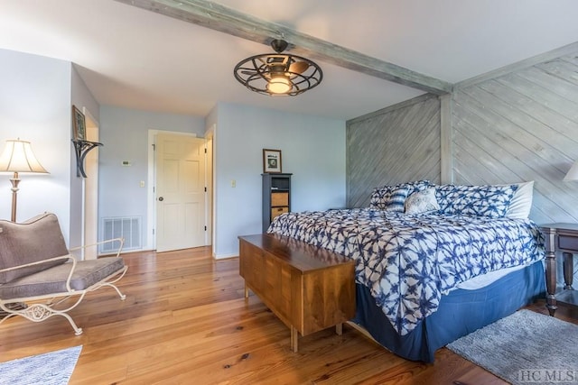 bedroom with wood-type flooring and beamed ceiling