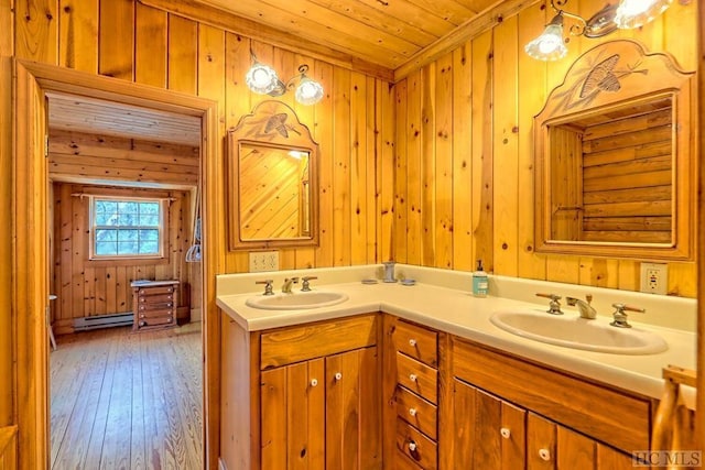 bathroom featuring baseboard heating, hardwood / wood-style floors, wood ceiling, and wooden walls