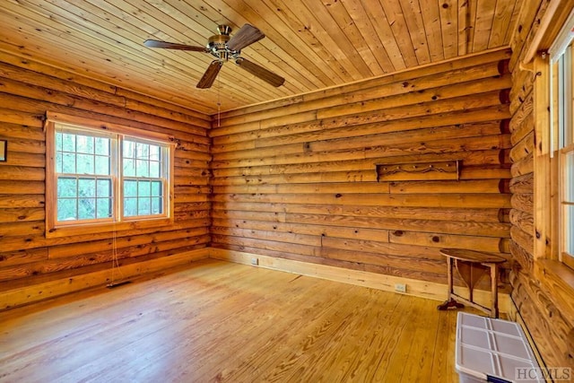 empty room featuring wood ceiling, rustic walls, and light hardwood / wood-style floors