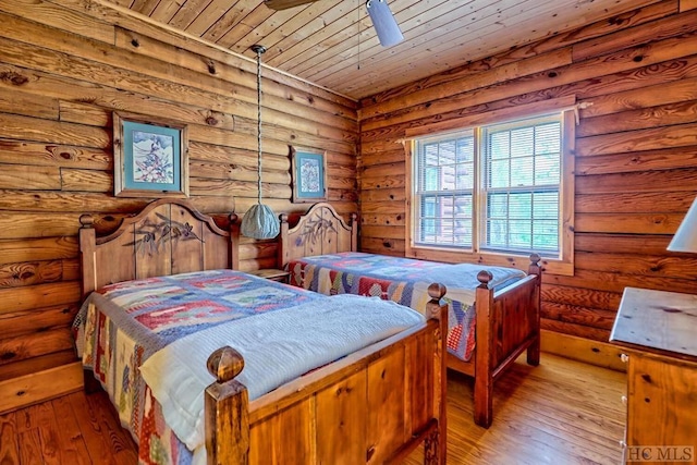 bedroom with wooden ceiling, hardwood / wood-style floors, ceiling fan, and log walls