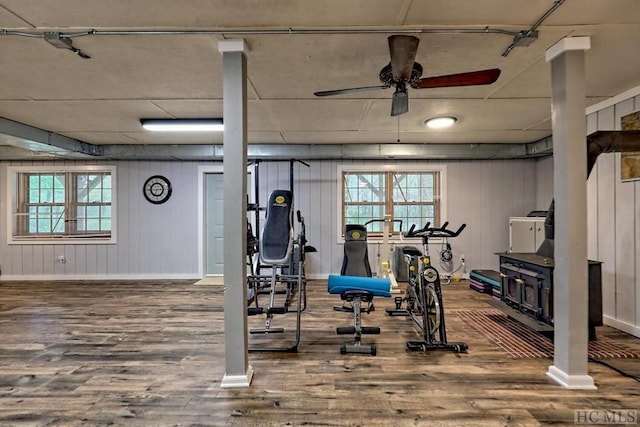 workout area with ceiling fan, hardwood / wood-style flooring, wood walls, and a healthy amount of sunlight