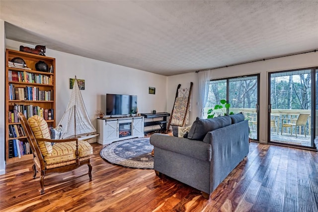 living area with a textured ceiling and wood finished floors