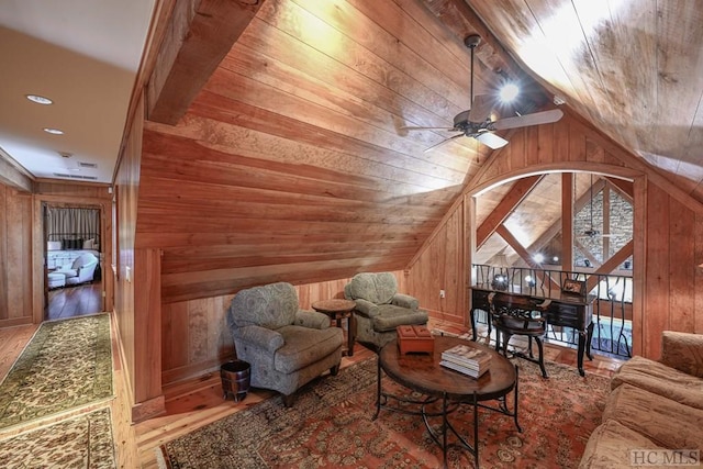 living room with ceiling fan, wooden ceiling, and wooden walls