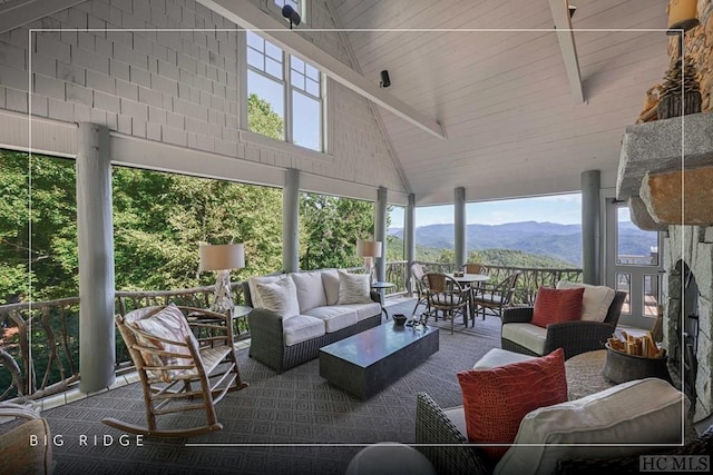 sunroom / solarium with a mountain view and lofted ceiling with beams