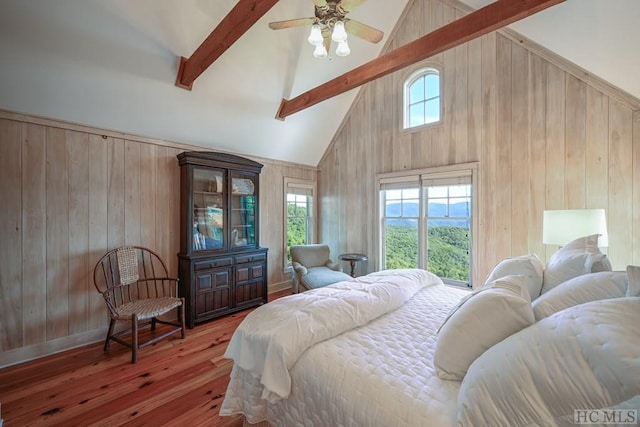 bedroom with high vaulted ceiling, wood walls, beamed ceiling, wood-type flooring, and ceiling fan