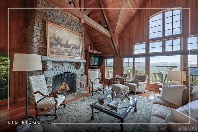 living room with hardwood / wood-style floors, high vaulted ceiling, a fireplace, wood walls, and wood ceiling