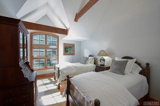 bedroom with vaulted ceiling with beams and light tile patterned floors