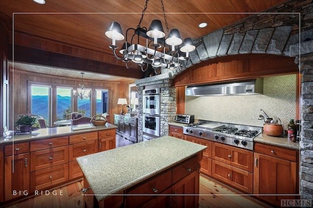 kitchen featuring an inviting chandelier, appliances with stainless steel finishes, wall chimney exhaust hood, and wood ceiling