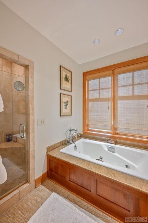 bathroom featuring shower with separate bathtub and tile patterned flooring