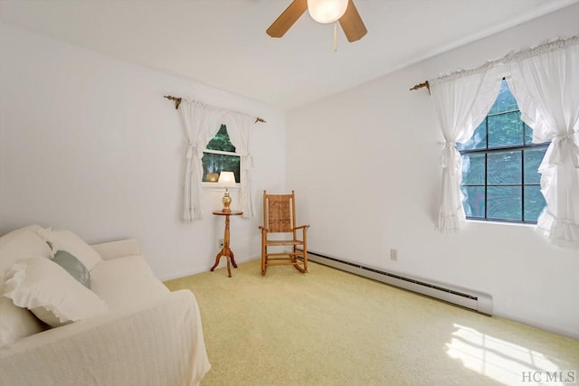 living area with a healthy amount of sunlight, baseboard heating, ceiling fan, and carpet flooring