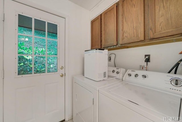 laundry area with cabinets and washing machine and clothes dryer