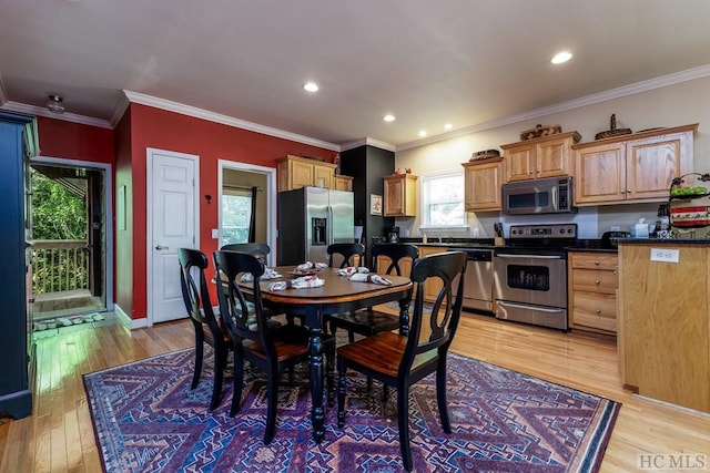 dining area with light wood-type flooring and crown molding