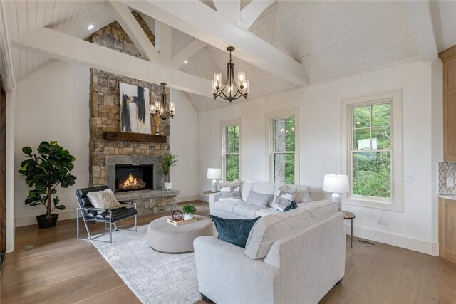 343 Ledgeview Rd, Cashiers, NC 28717 - living area with healthy amount of natural light, a stone fireplace, a chandelier, and light wood-type flooring