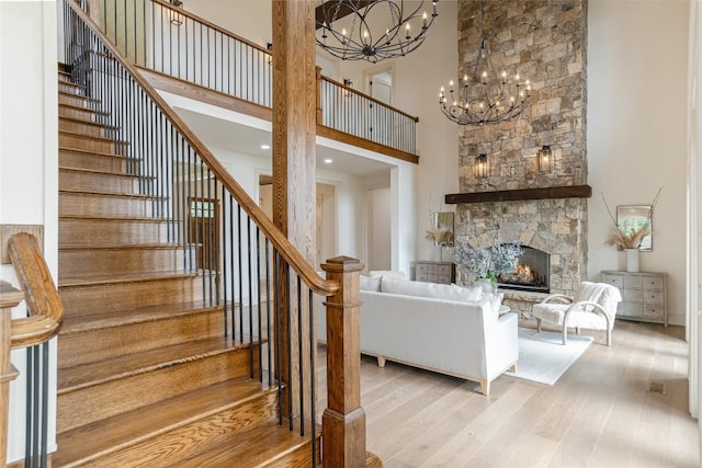 343 Ledgeview Rd, Cashiers, NC 28717 - living area featuring a high ceiling, stairway, wood finished floors, a chandelier, and a fireplace