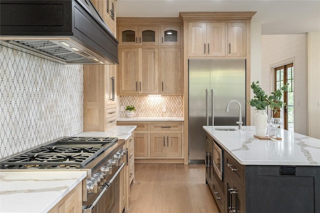 343 Ledgeview Rd, Cashiers, NC 28717 - kitchen featuring stainless steel appliances, light wood finished floors, custom exhaust hood, a center island with sink, and decorative backsplash