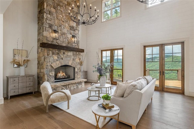 343 Ledgeview Rd, Cashiers, NC 28717 - living area featuring french doors, wood finished floors, a towering ceiling, a chandelier, and a stone fireplace