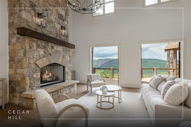 343 Ledgeview Rd, Cashiers, NC 28717 - living room featuring a high ceiling, a chandelier, a stone fireplace, wood finished floors, and a mountain view
