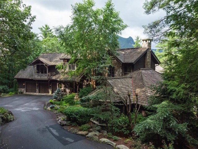 1090 Zeb Alley Rd, Cashiers, NC 28717 - view of front of property featuring asphalt driveway, a chimney, an attached garage, and stone siding